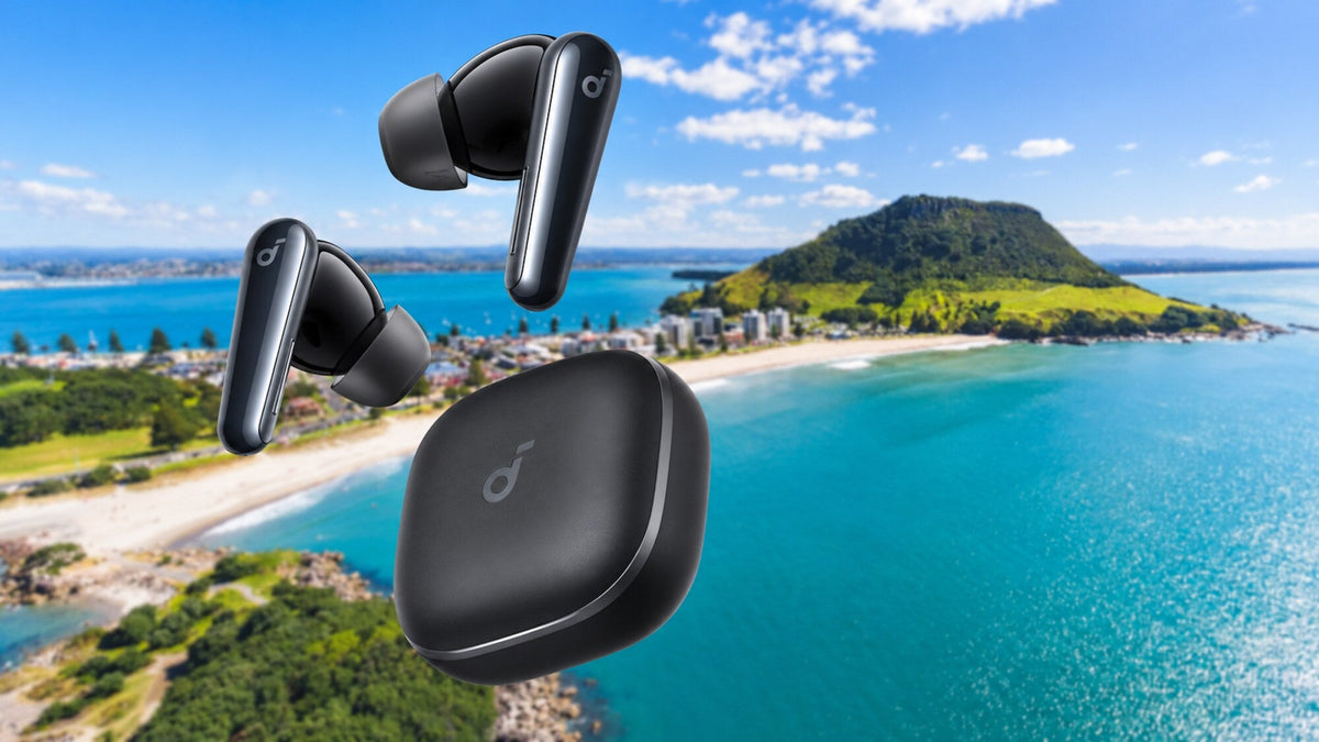 Black soundcore Liberty 5 earbuds and charging case with Mount Maunganui and its beach slightly blurred in the background.