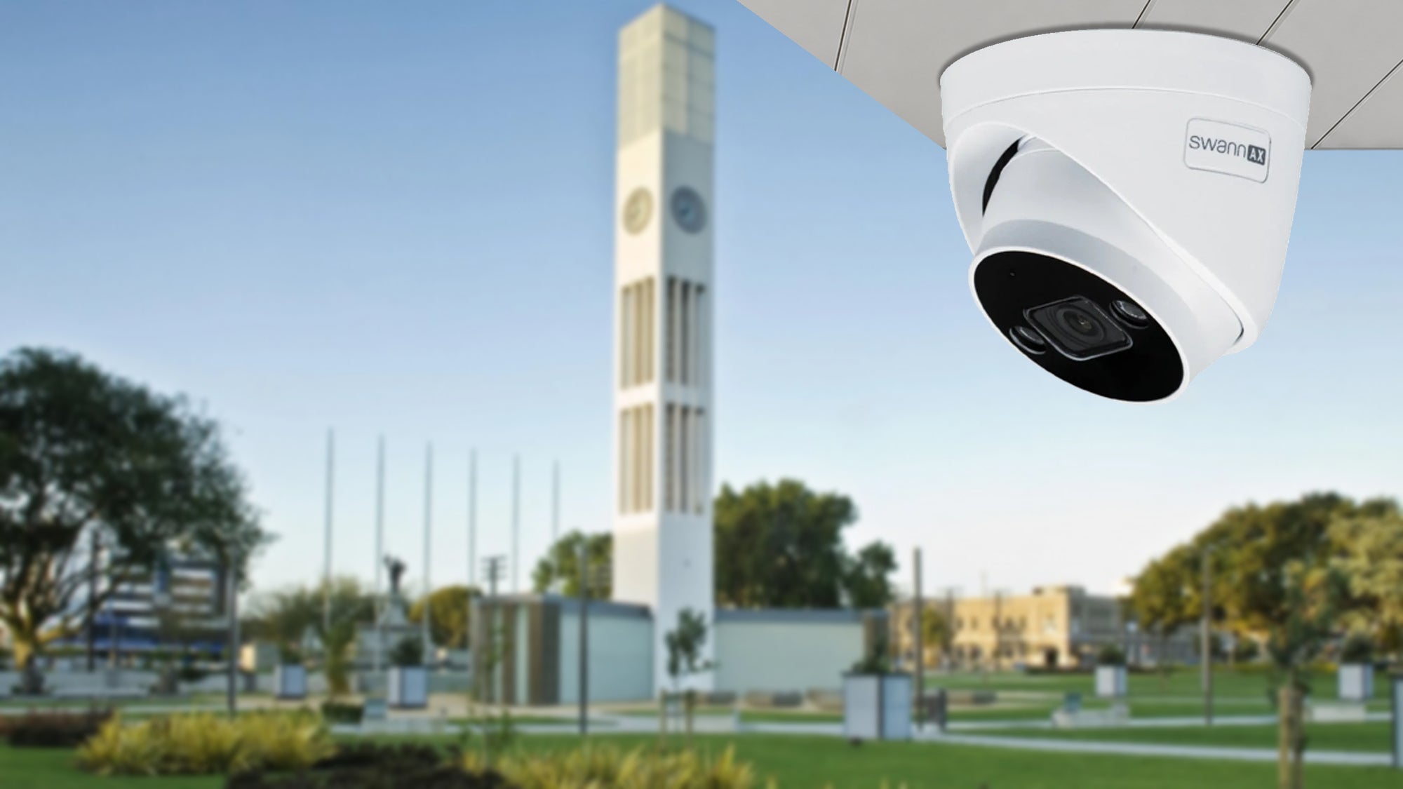 Swann AX security camera mounted beneath a canopy with Palmerston North’s The Square clock tower blurred in the background - Security Cameras at Tech Supply Shed NZ