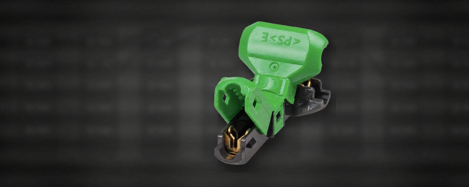Green electrical connector terminal with brass contacts on a dark technical background
