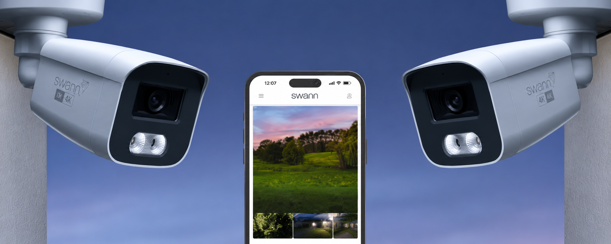 Two Swann 4K outdoor security cameras positioned on either side of a smartphone displaying live CCTV footage through the Swann security app for home surveillance in New Zealand.