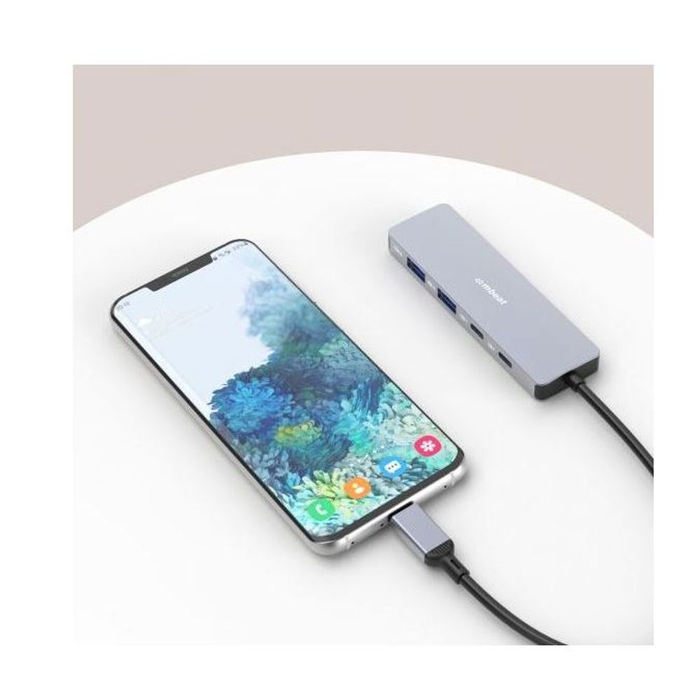 Grey USB-C hub powering a smartphone with connected USB ports