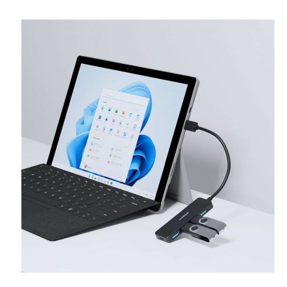 USB hub next to laptop keyboard and tablet, with four blue ports