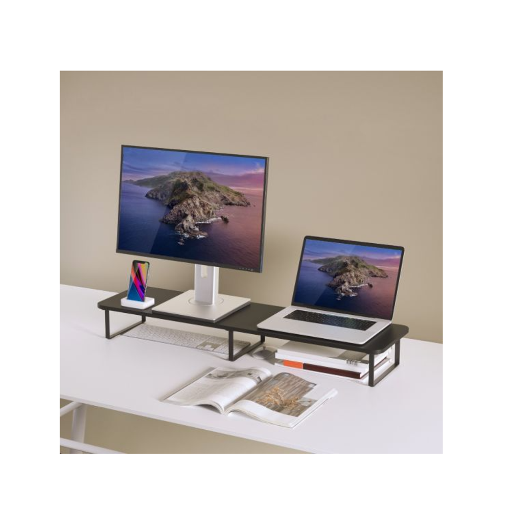 Black dual monitor riser stand on a desk with two monitors and a small accessory.