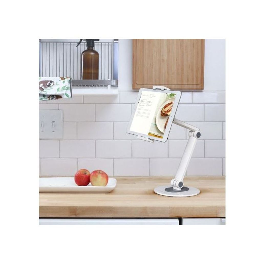 White tablet stand on countertop holding a tablet for reading