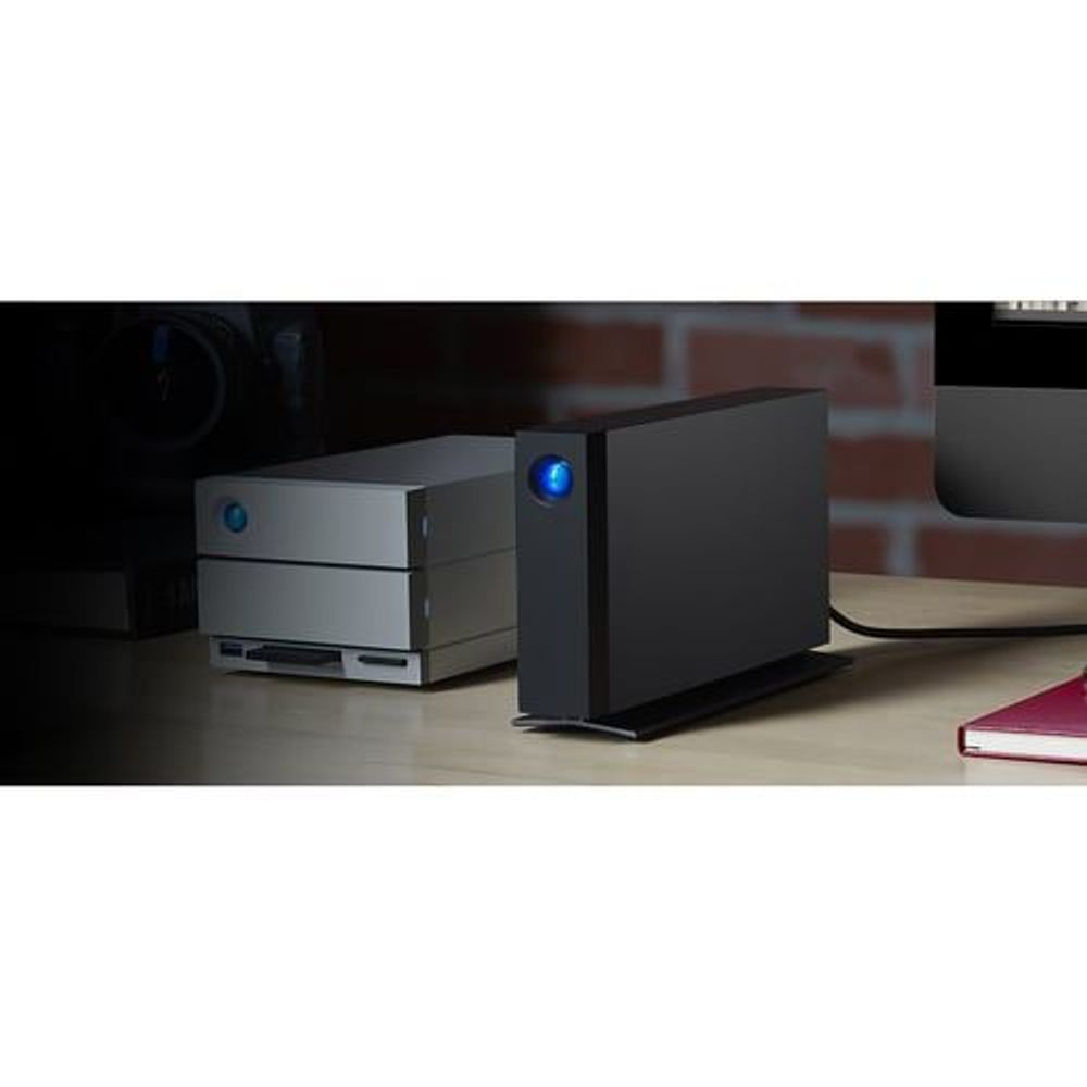 Black external desktop hard drive with blue LED on desk surface