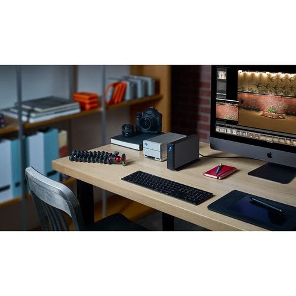 Black desktop external hard drive with blue LED on a workstation table