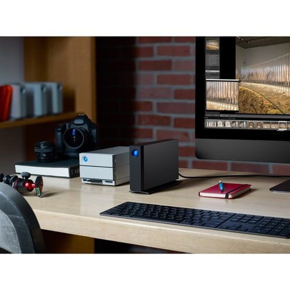 Black desktop external hard drive with blue LED sitting on a wooden desk