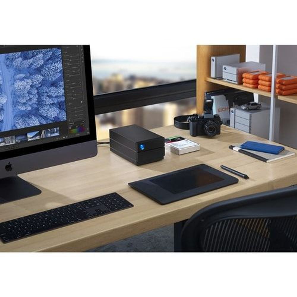 Black desktop RAID storage on a desk with blue status light
