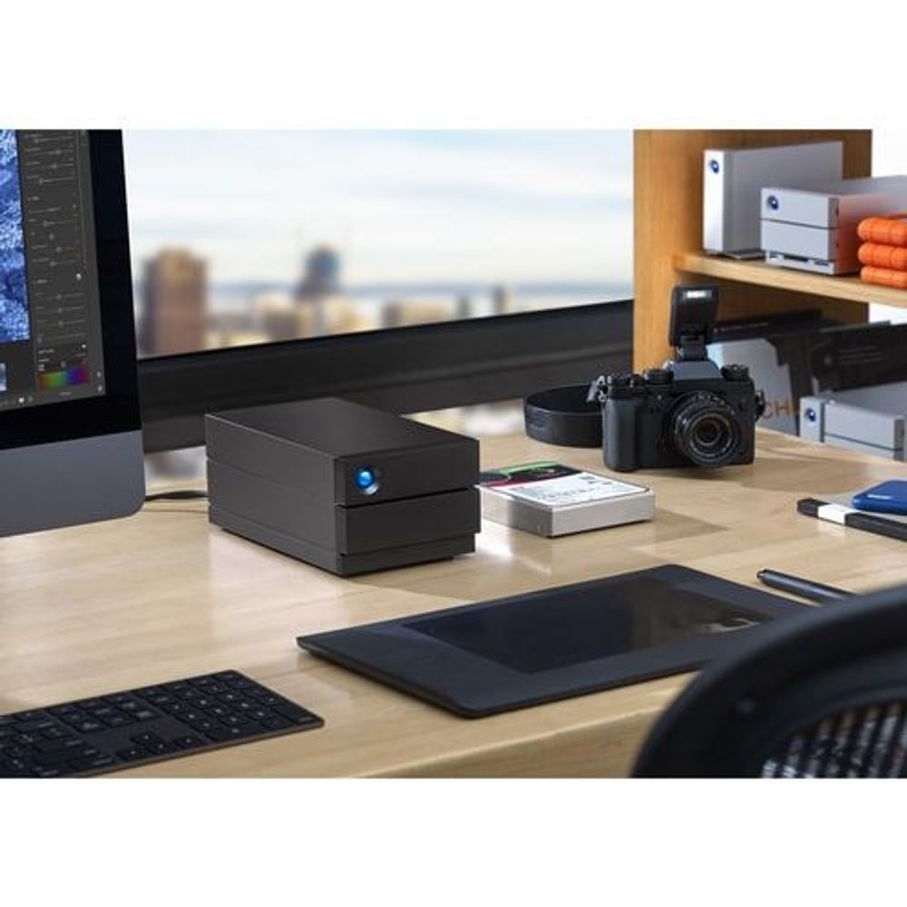 Black desktop RAID storage on a workbench with blue status light