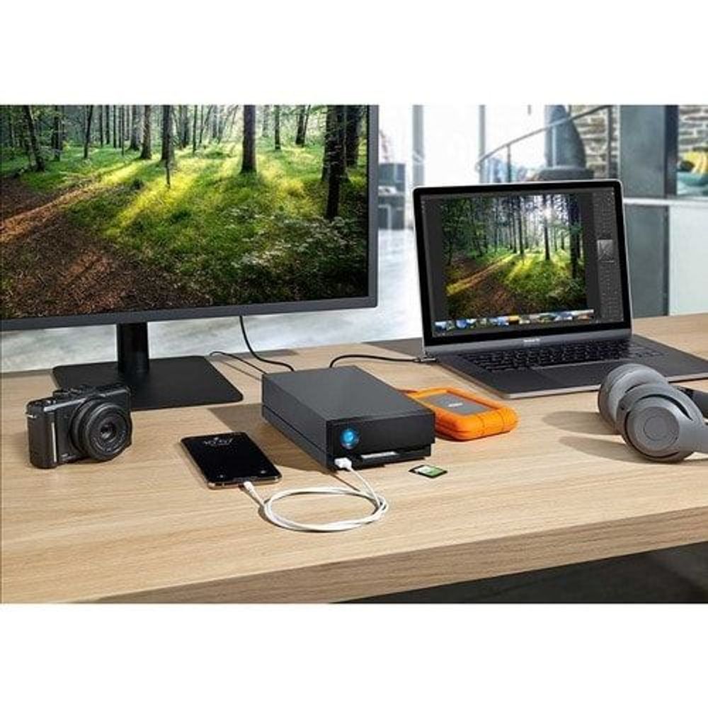 Desktop setup with black external hard drive connected to devices on a work table.