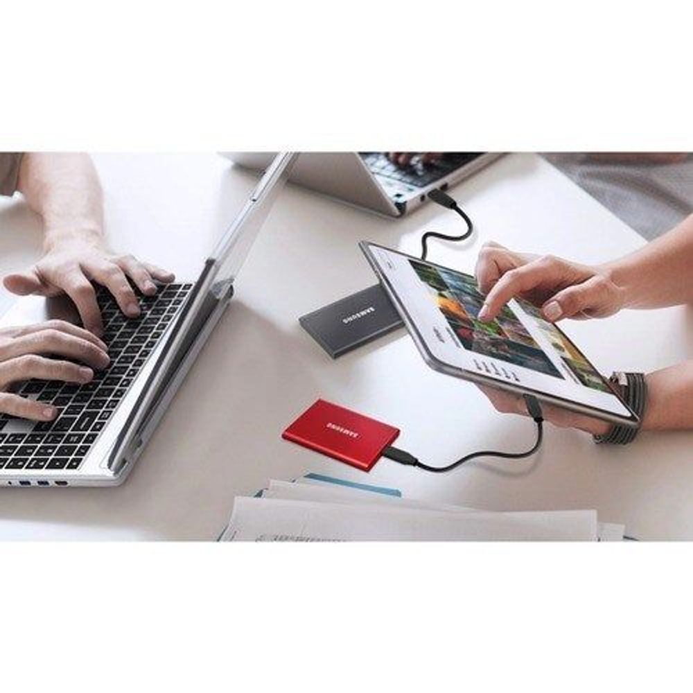 Red Samsung Portable SSD T7 connected to a tablet via USB cable