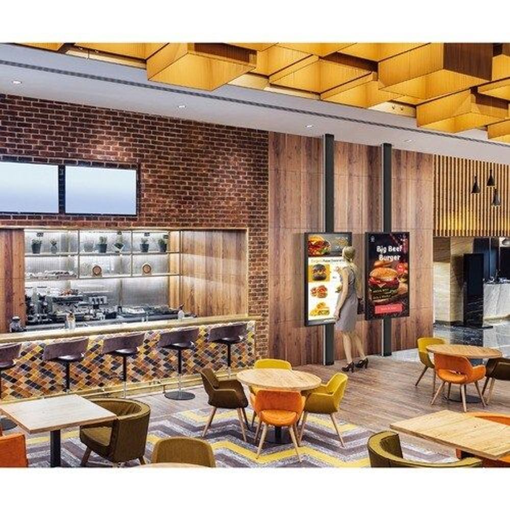 32-inch touchscreen digital signage display mounted in a restaurant lobby