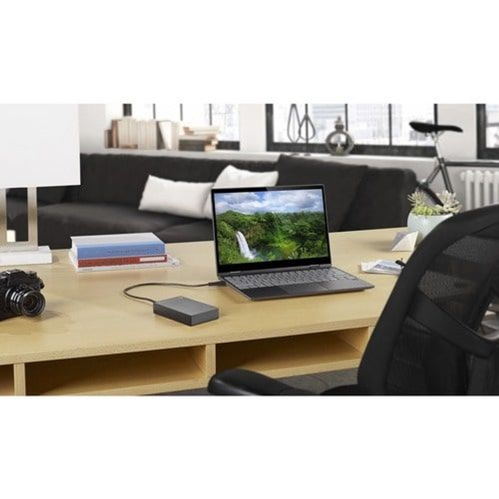 Space gray portable hard drive connected to a laptop with a USB cable