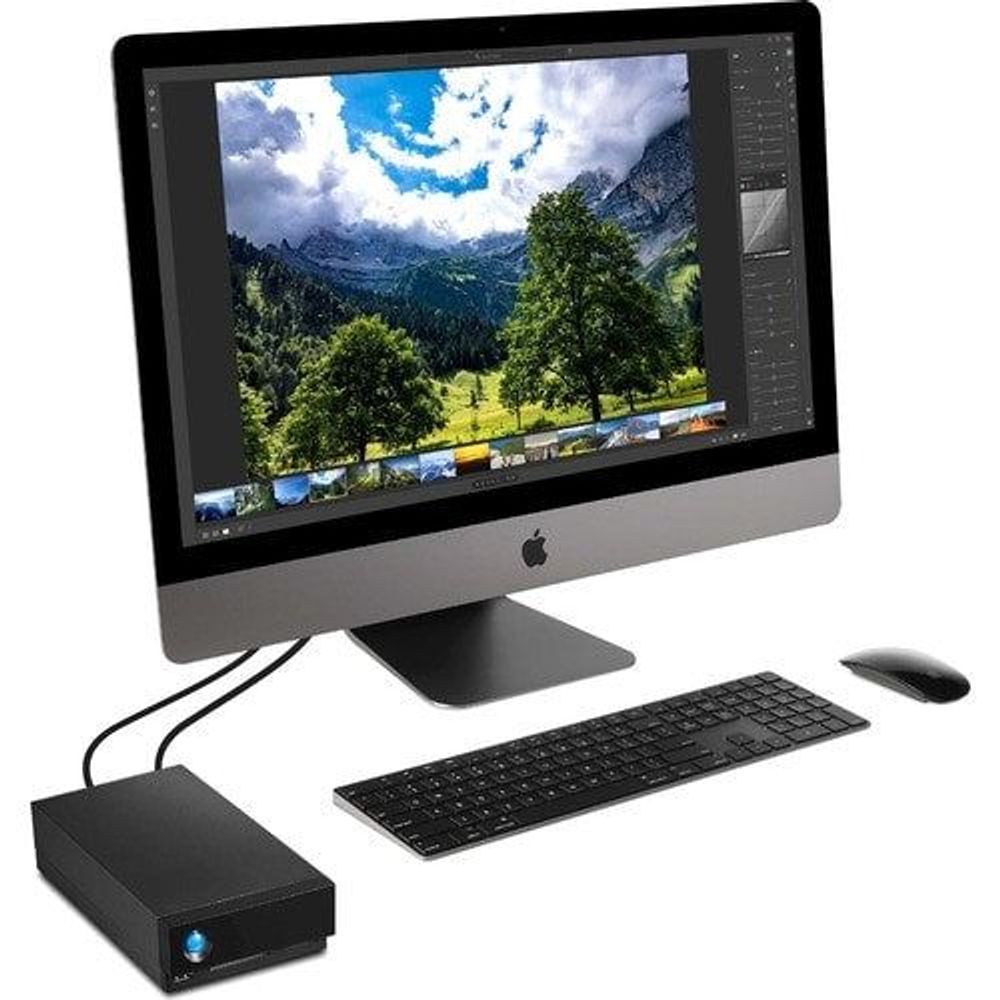 Black desktop external hard drive with blue LED connected to a computer setup