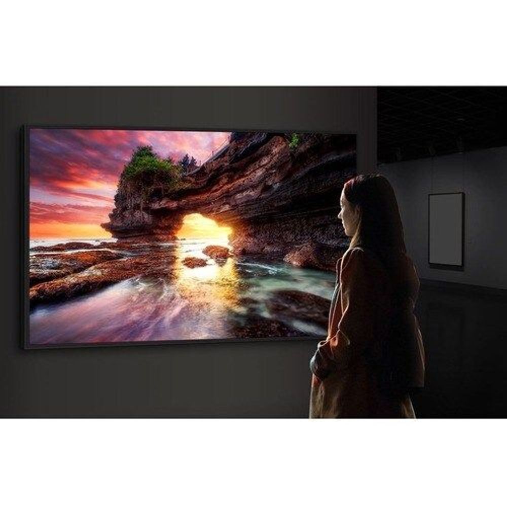 Wall-mounted digital signage display showing landscape sunset scene