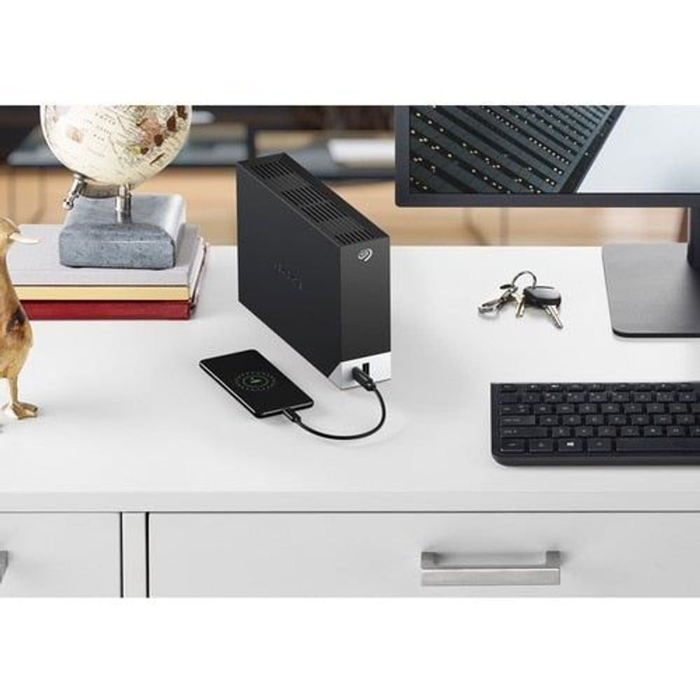 Black Seagate external hard drive with USB-C cable connected to a laptop