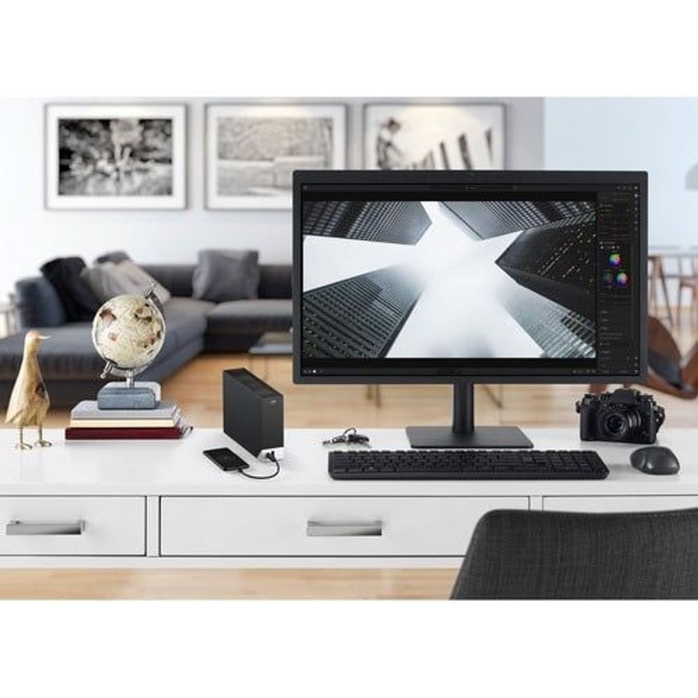 Black Seagate external hard drive placed near desktop monitor and keyboard