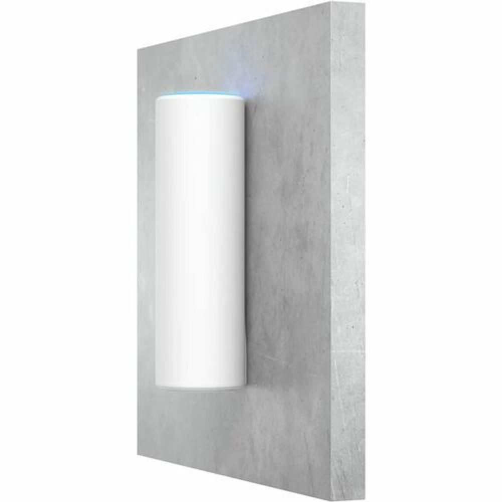 White cylindrical Ubiquiti access point installed in a wall-mounted recess.