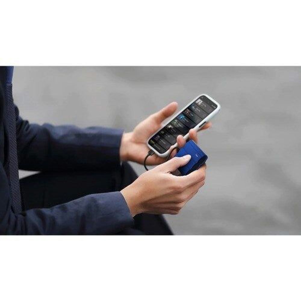 Portable SSD cable connected while a person holds a smartphone