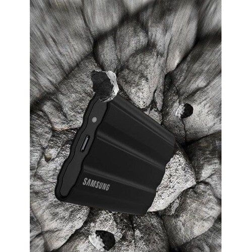 Black Samsung T7 rugged portable SSD with strap/handle on fabric