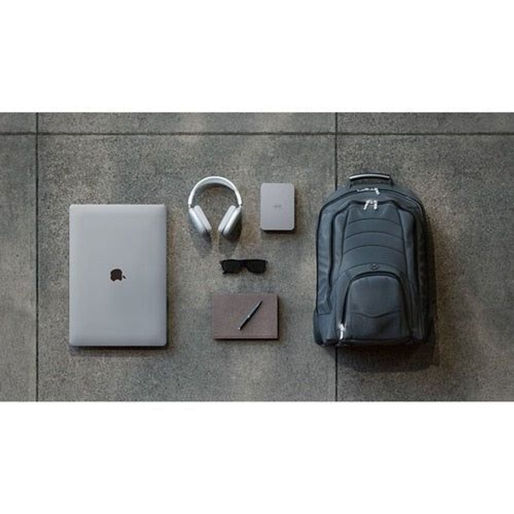 Portable hard drive with travel accessories laid out on gray floor