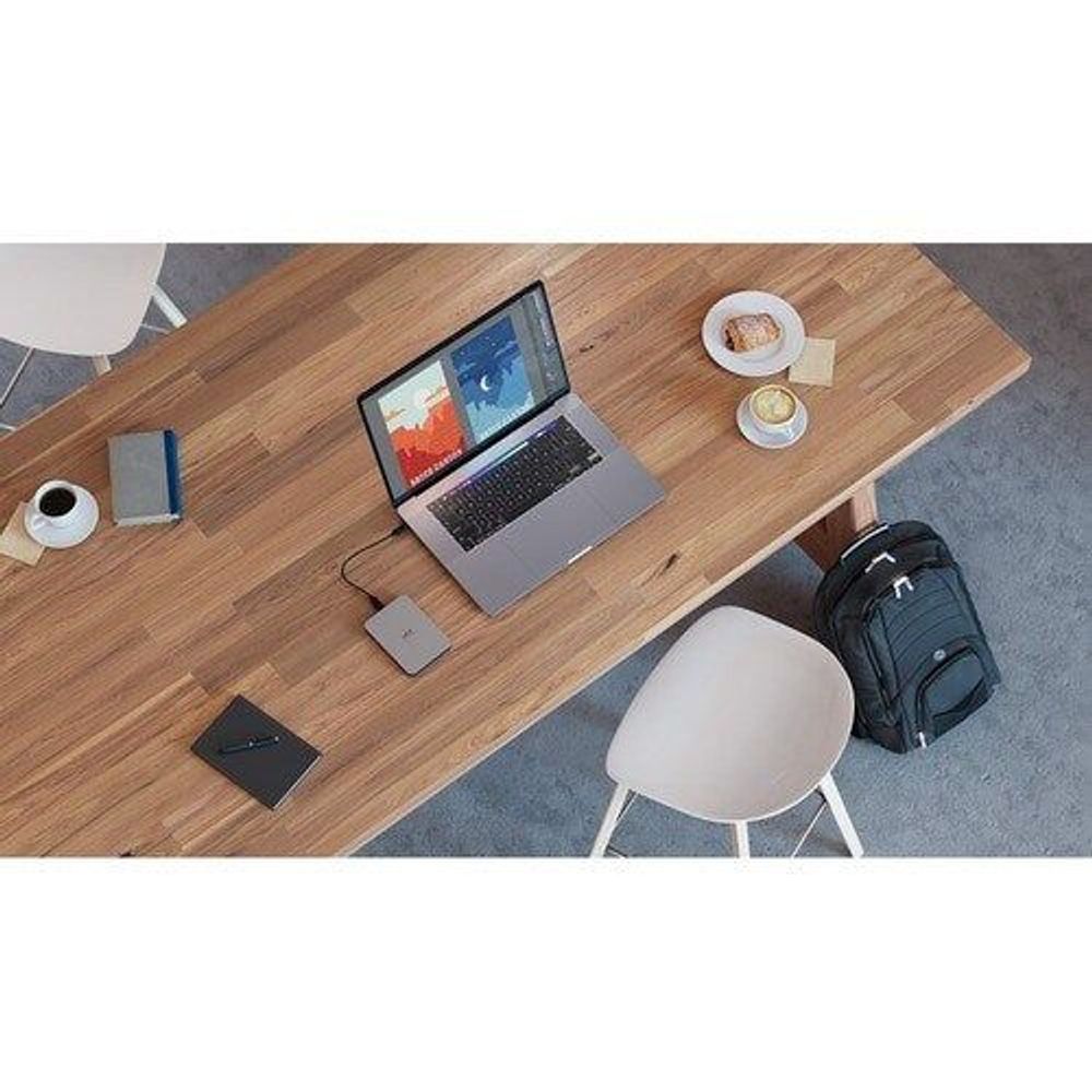 LaCie portable hard drive on desk beside open laptop