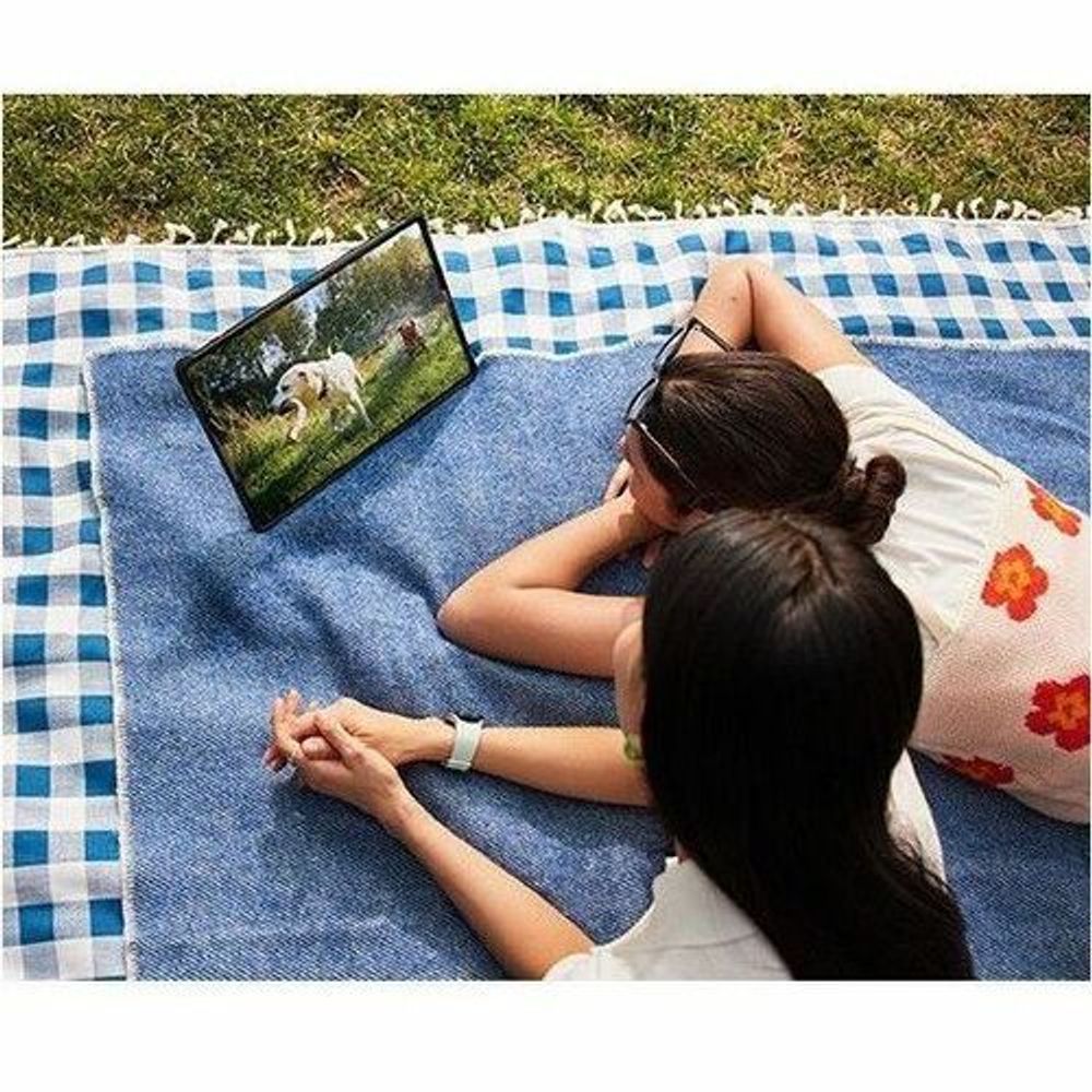 Rugged tablet resting on blue denim blanket with screen turned on