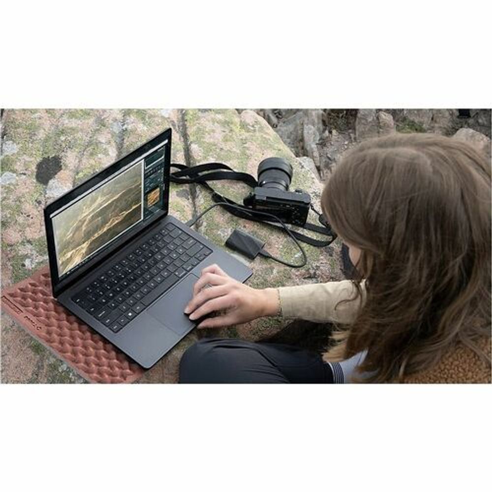 Black portable SSD connected near laptop keyboard