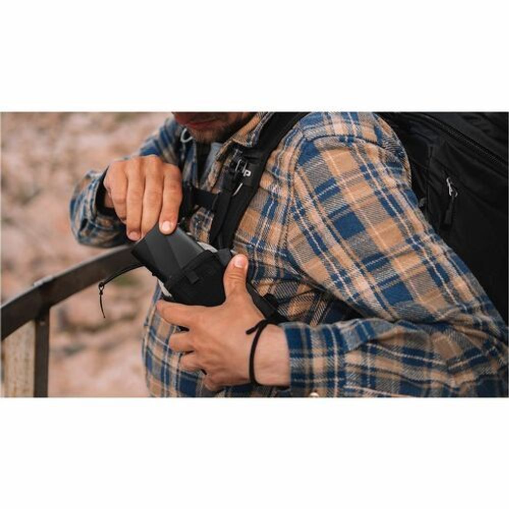 Black portable SSD being held in a hand with side ports visible