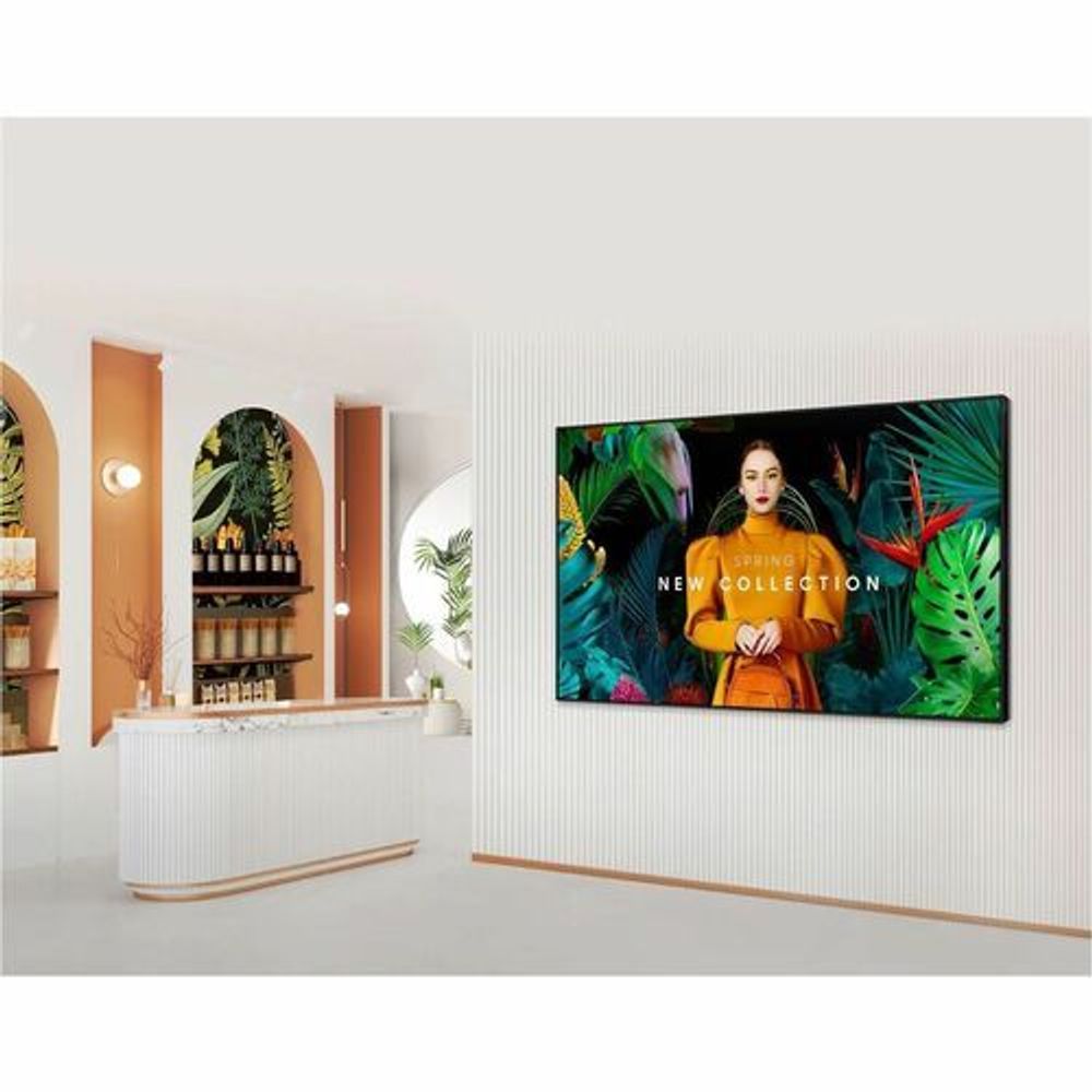 Digital signage display mounted indoors showing 'New Collection' tropical ad.