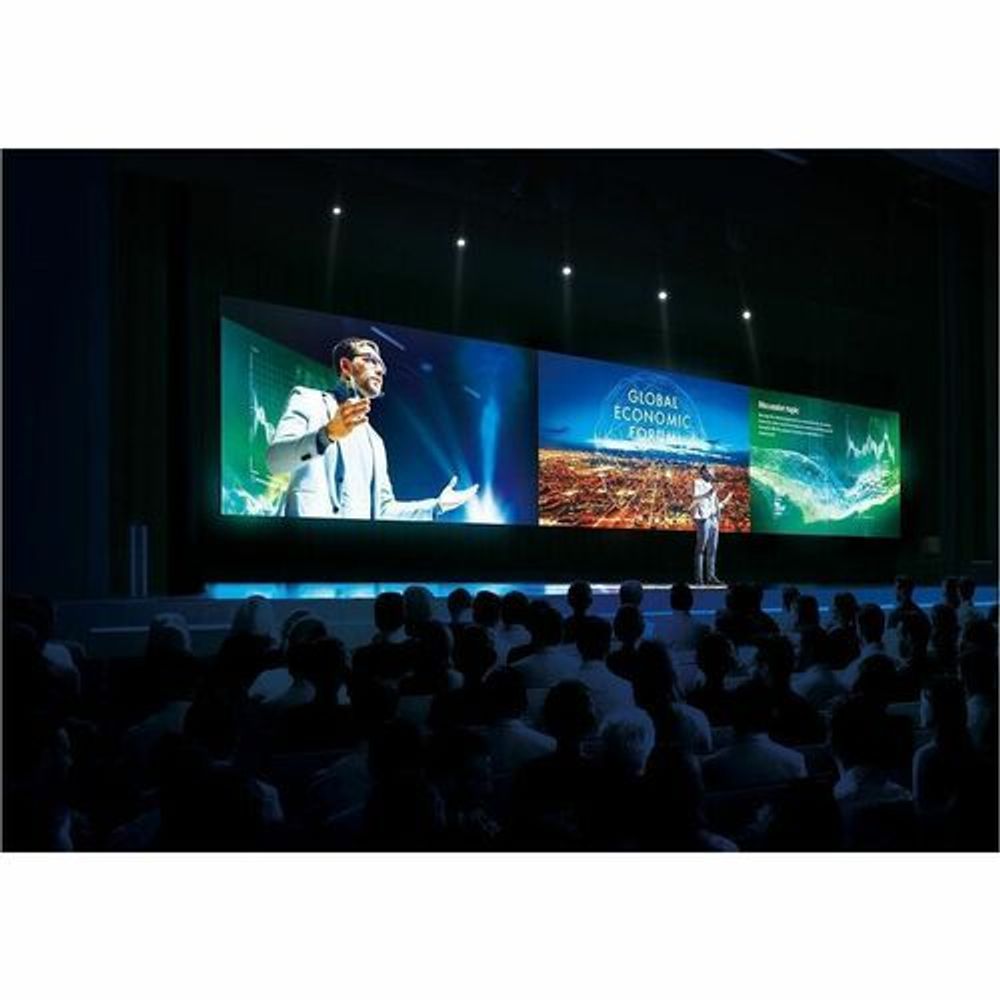 Indoor LED display panels on a conference stage with colorful slides