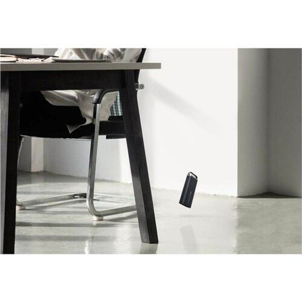 Black Samsung T5 EVO portable SSD hanging from a desk