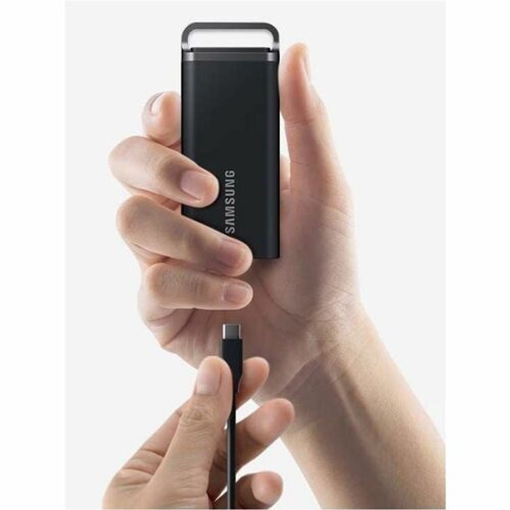 Black Samsung T5 EVO portable SSD held in hand with charging cable