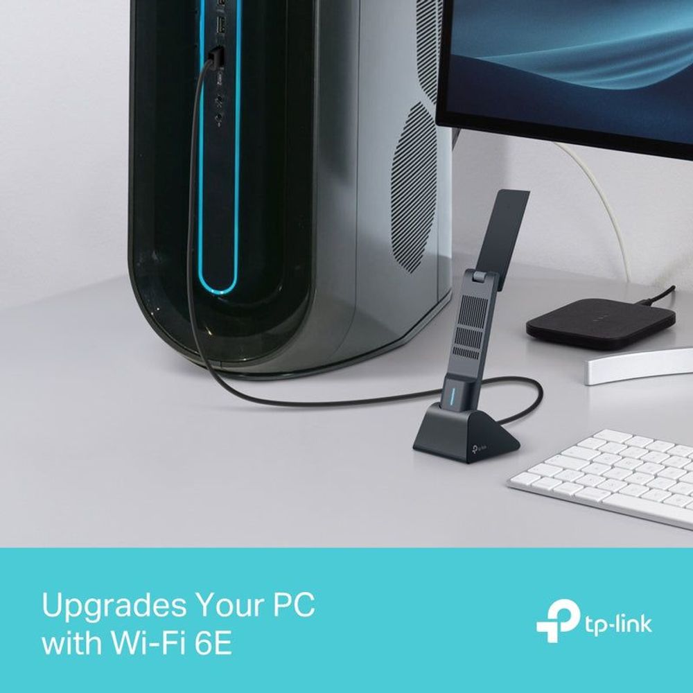 Wi‑Fi 6E USB wireless adapter on desk with upright antenna and power indicator