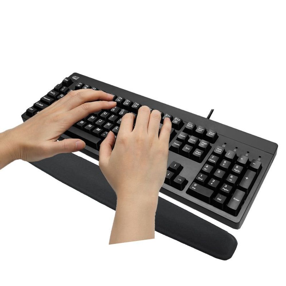 Black memory-foam wrist rest with Adesso logo, shown with hands typing