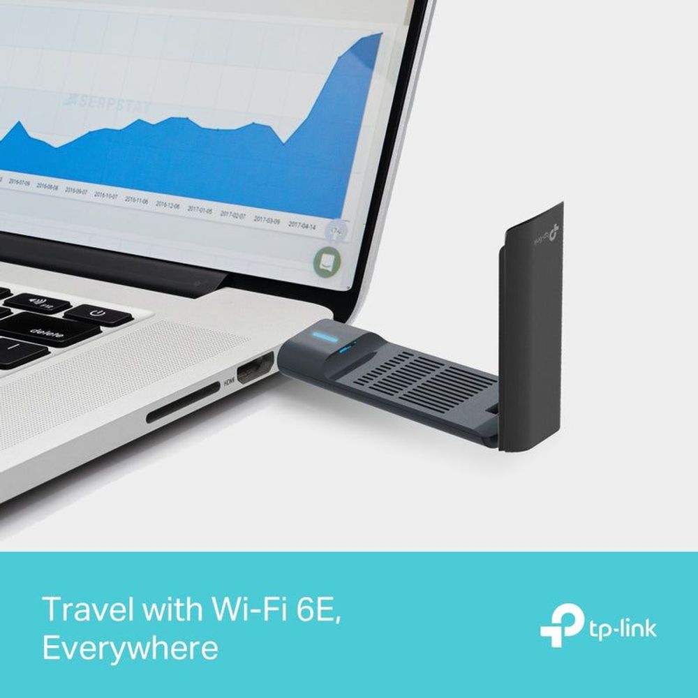 Wi‑Fi 6E USB wireless adapter connected near a laptop, dark body with blue light