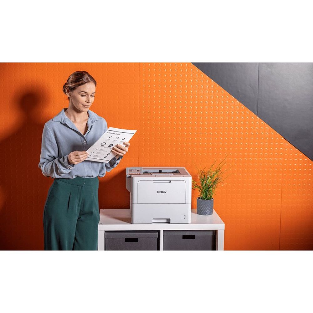 Monochrome laser printer on office table with control panel and paper output