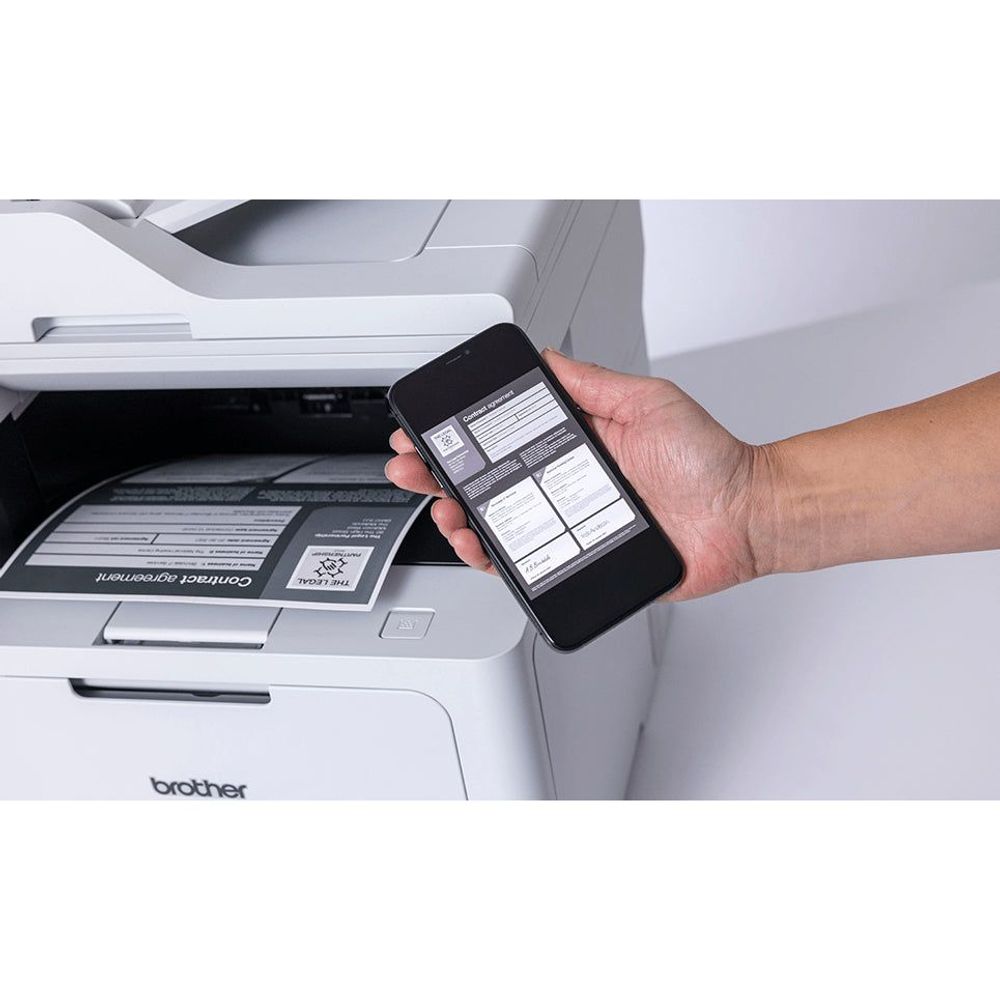 Monochrome laser printer with open tray; hand holding smartphone for setup