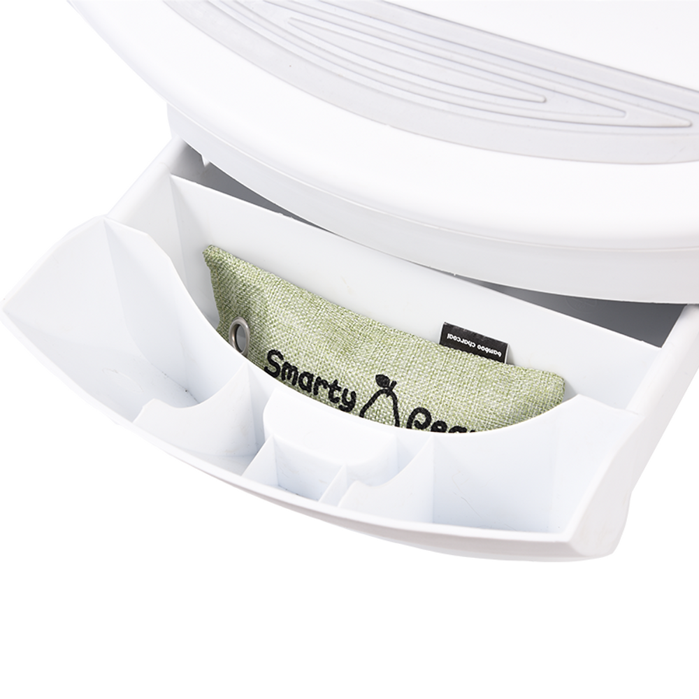 Green fabric air freshener pouch placed inside a white pet odor filter holder