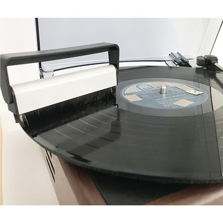 Carbon fiber cleaning brush in use on a vinyl record, black bristles and handle