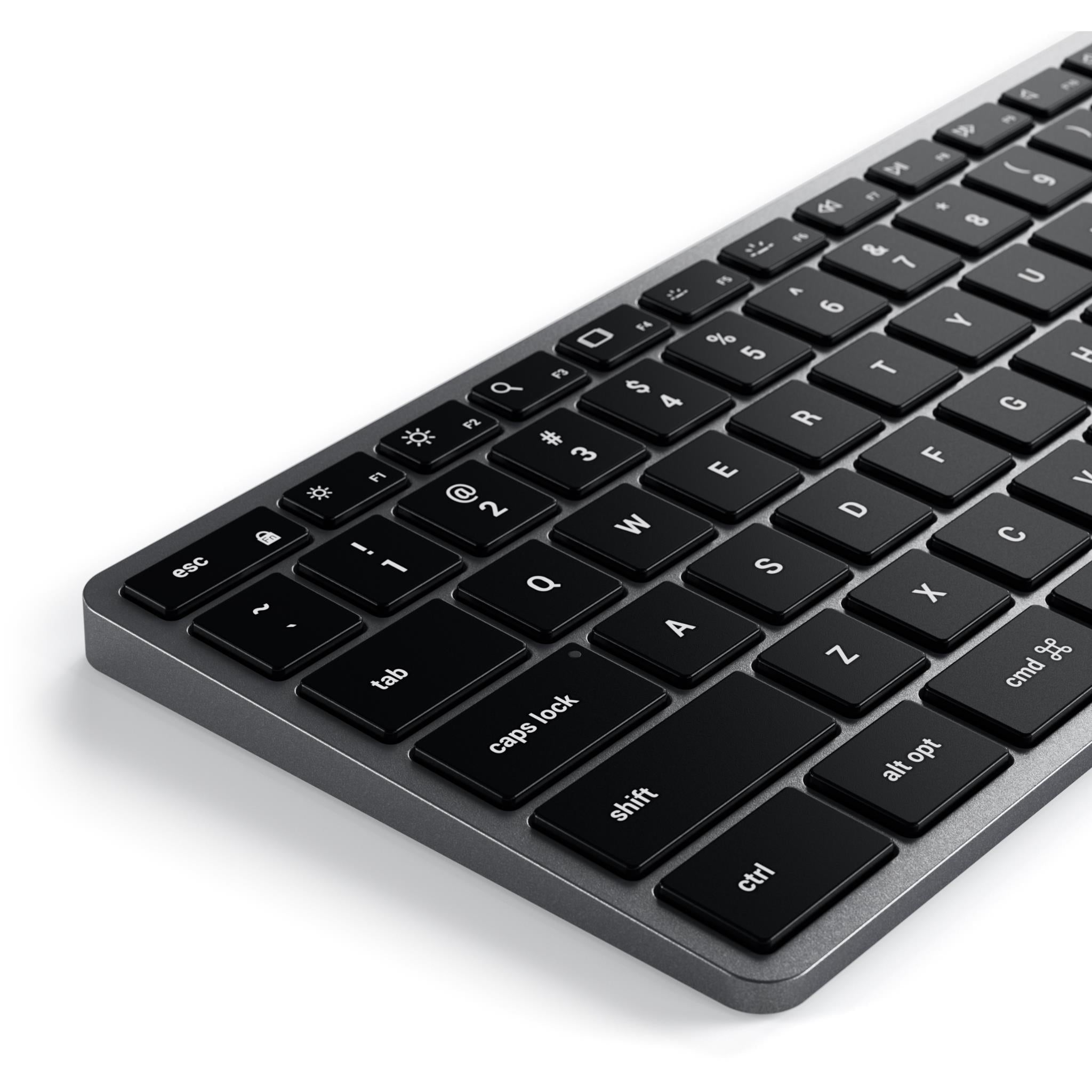 Space gray backlit Bluetooth Mac keyboard close-up of left keys with glowing legends
