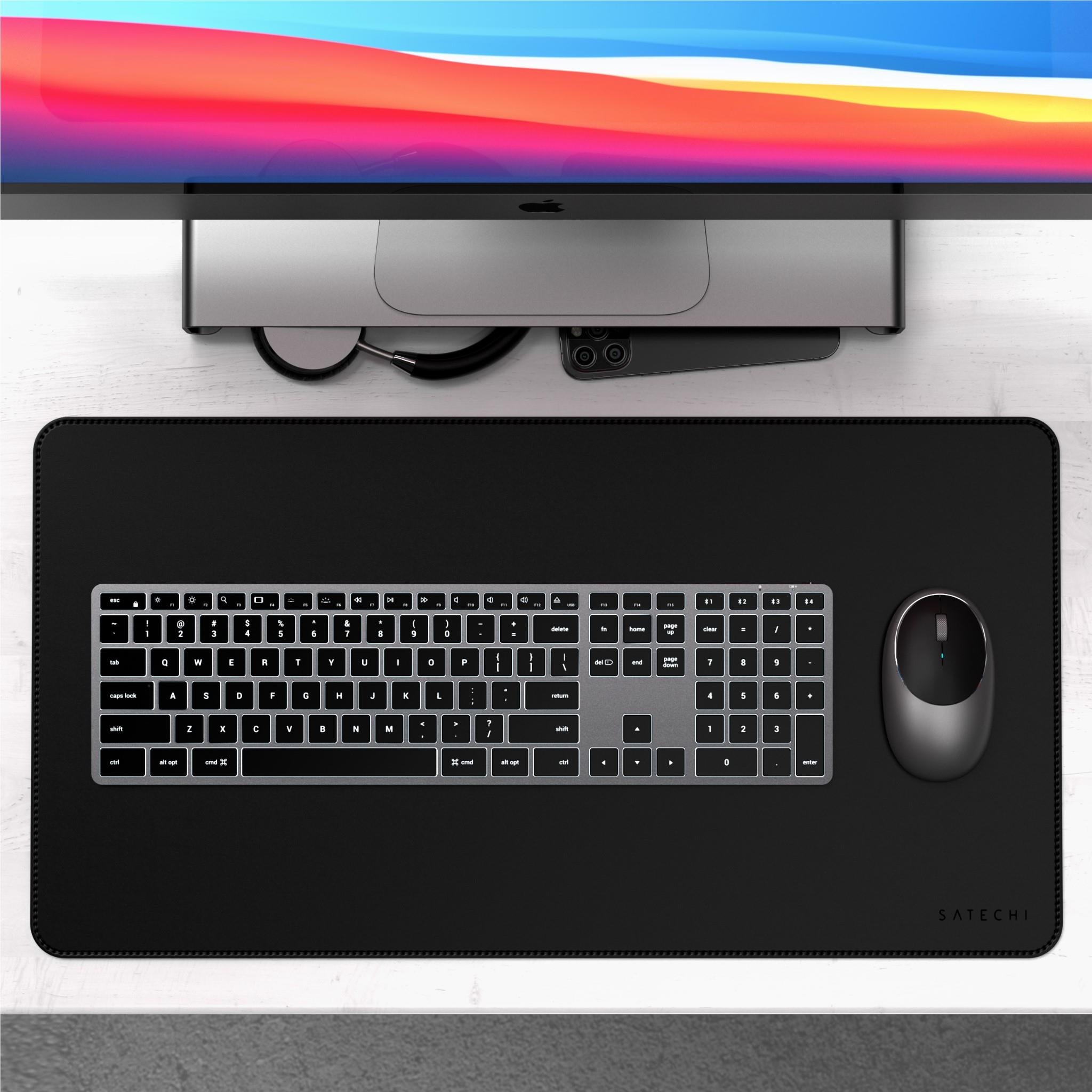 Backlit Bluetooth Mac keyboard on desk mat, black keys with illuminated characters