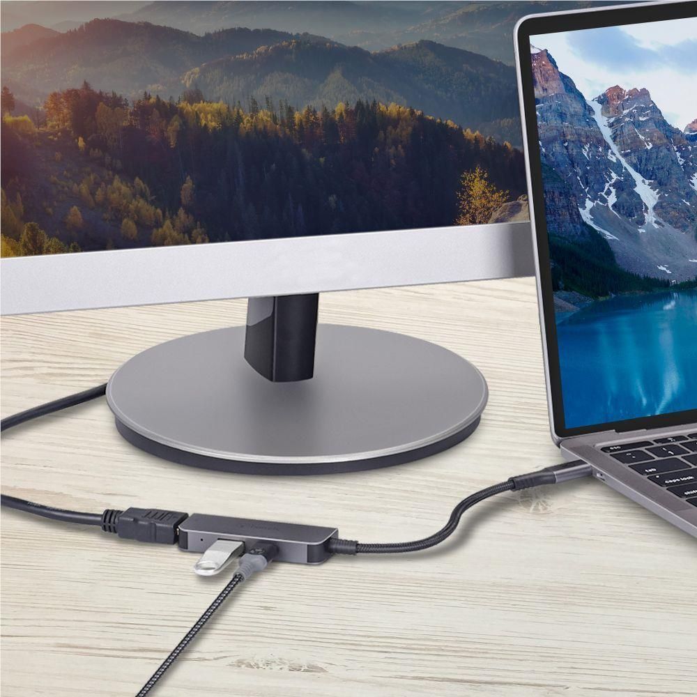 Space grey USB-C multiport hub with attached cables on desk, round base stand