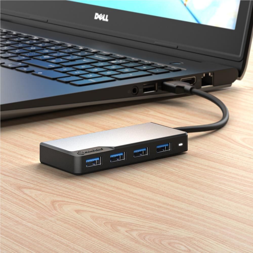 Space grey 4-port USB-A hub connected to laptop; blue USB ports visible