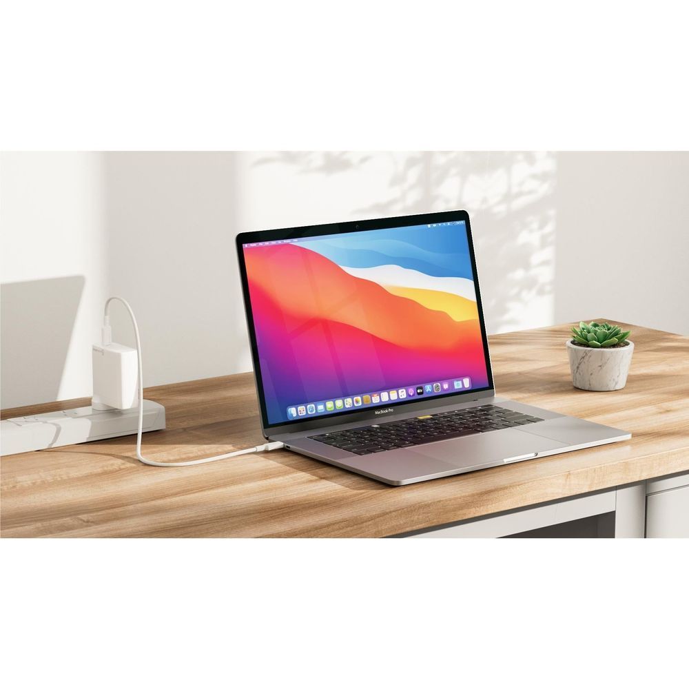 White 100W GaN wall charger powering a laptop via USB-C cable