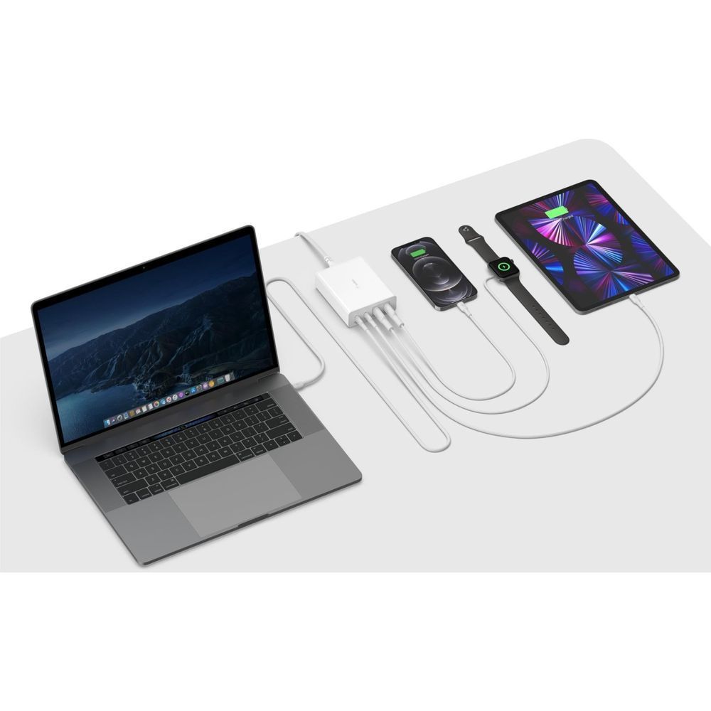 White 4-port GaN charger powering laptop and two smartphones with connected cables