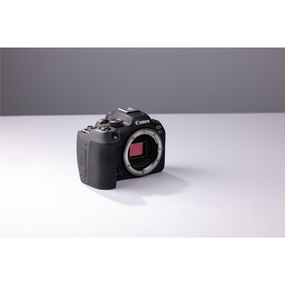 Canon EOS R7 mirrorless camera body with exposed sensor and viewfinder, 3/4 view