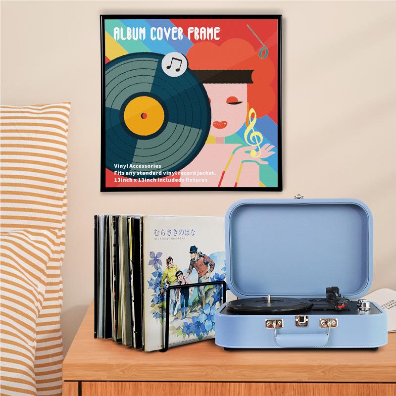 Black album cover frame on display with vinyl record sleeves and blue record player