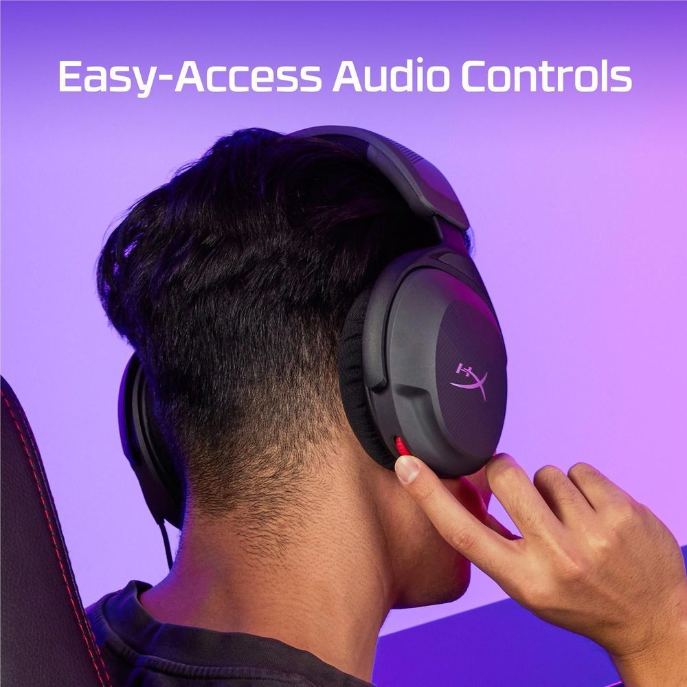 Black wired gaming headset worn, with hand adjusting the earcup