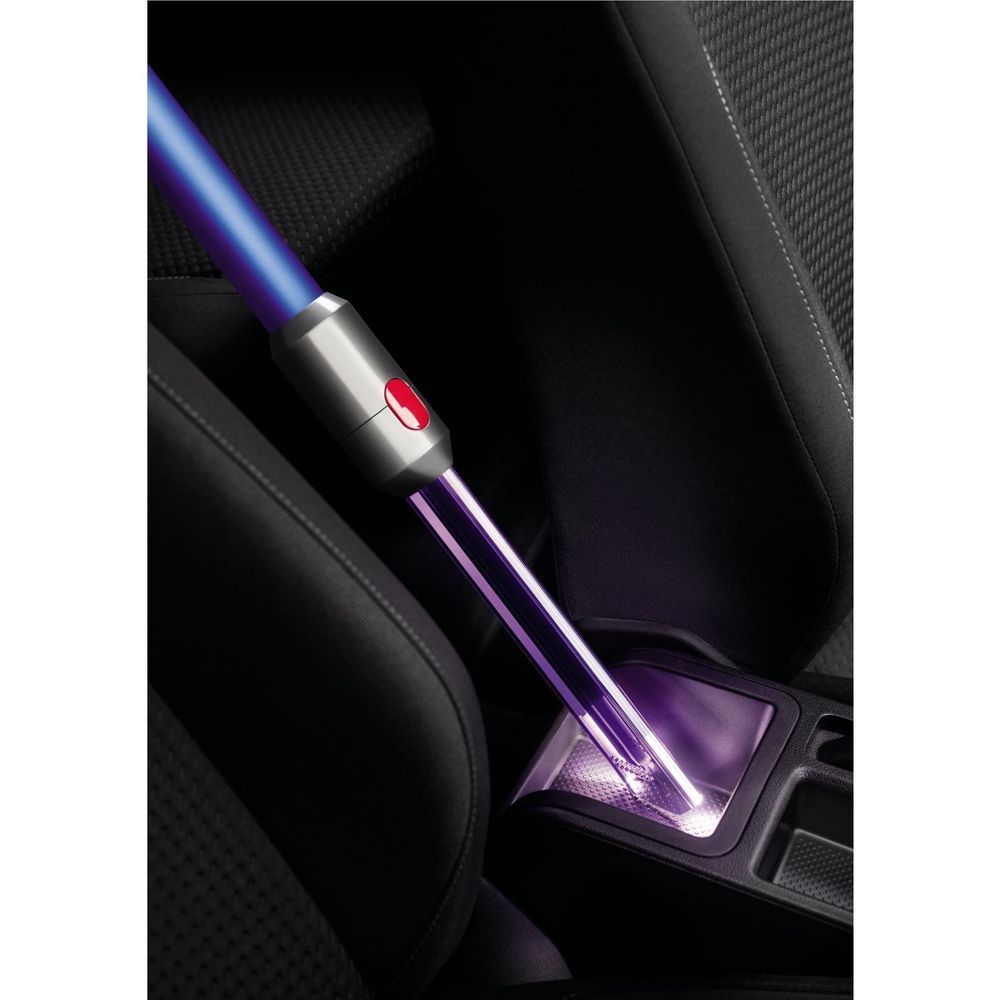 Purple crevice tool vacuuming between car seats with light pipe tip
